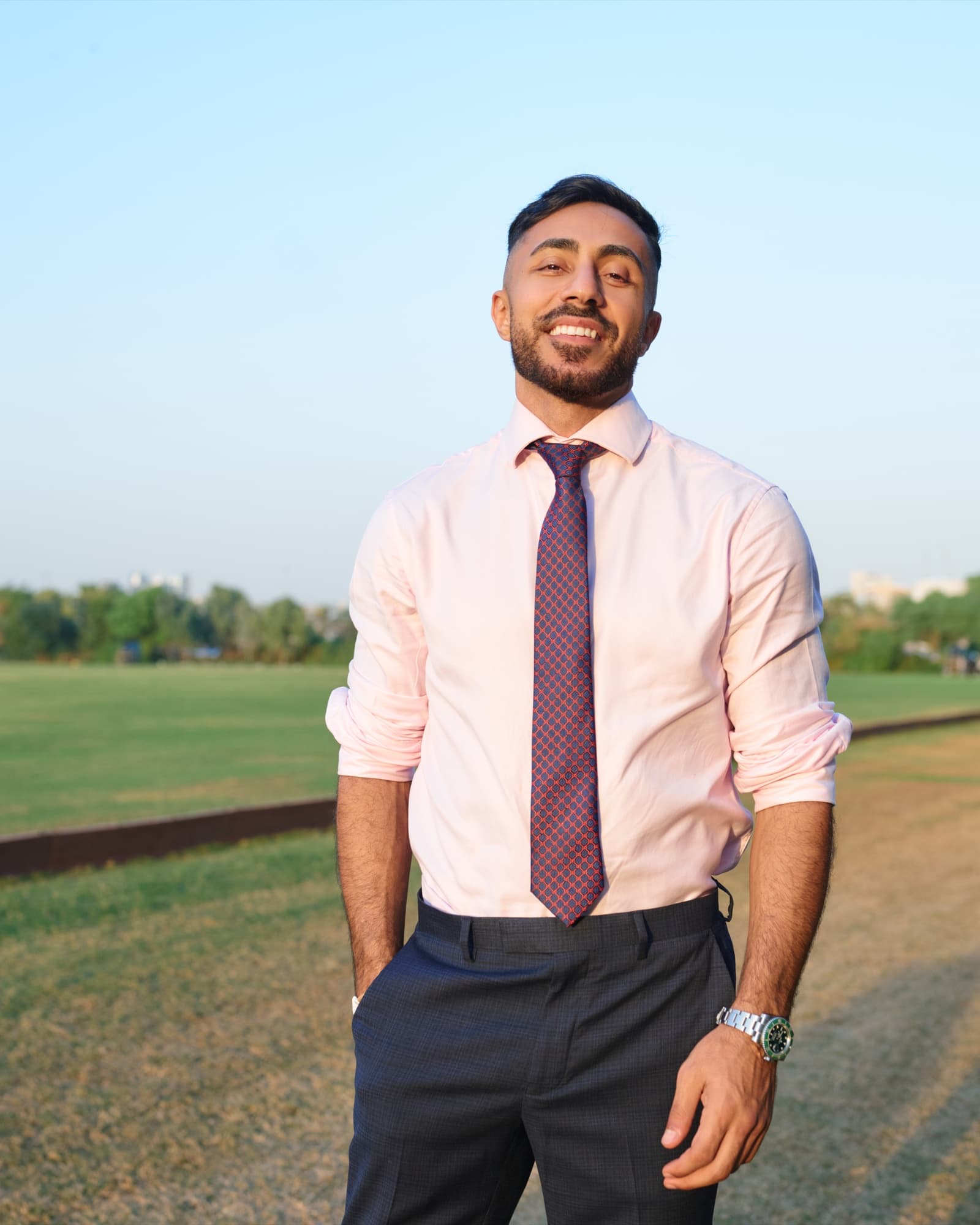 Personal brand photography by Deine, male executive in a pink shirt outdoors at golden hour